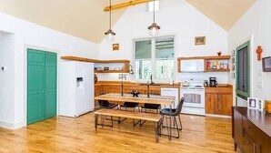 Una cocina con vigas de madera, una mesa de comedor y un refrigerador.