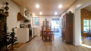 Una cocina con armarios blancos, techo de madera y vistas al exterior.