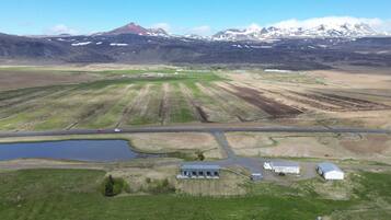 An aerial view of a rural landscape with fields, a small body of water, and a few buildings.