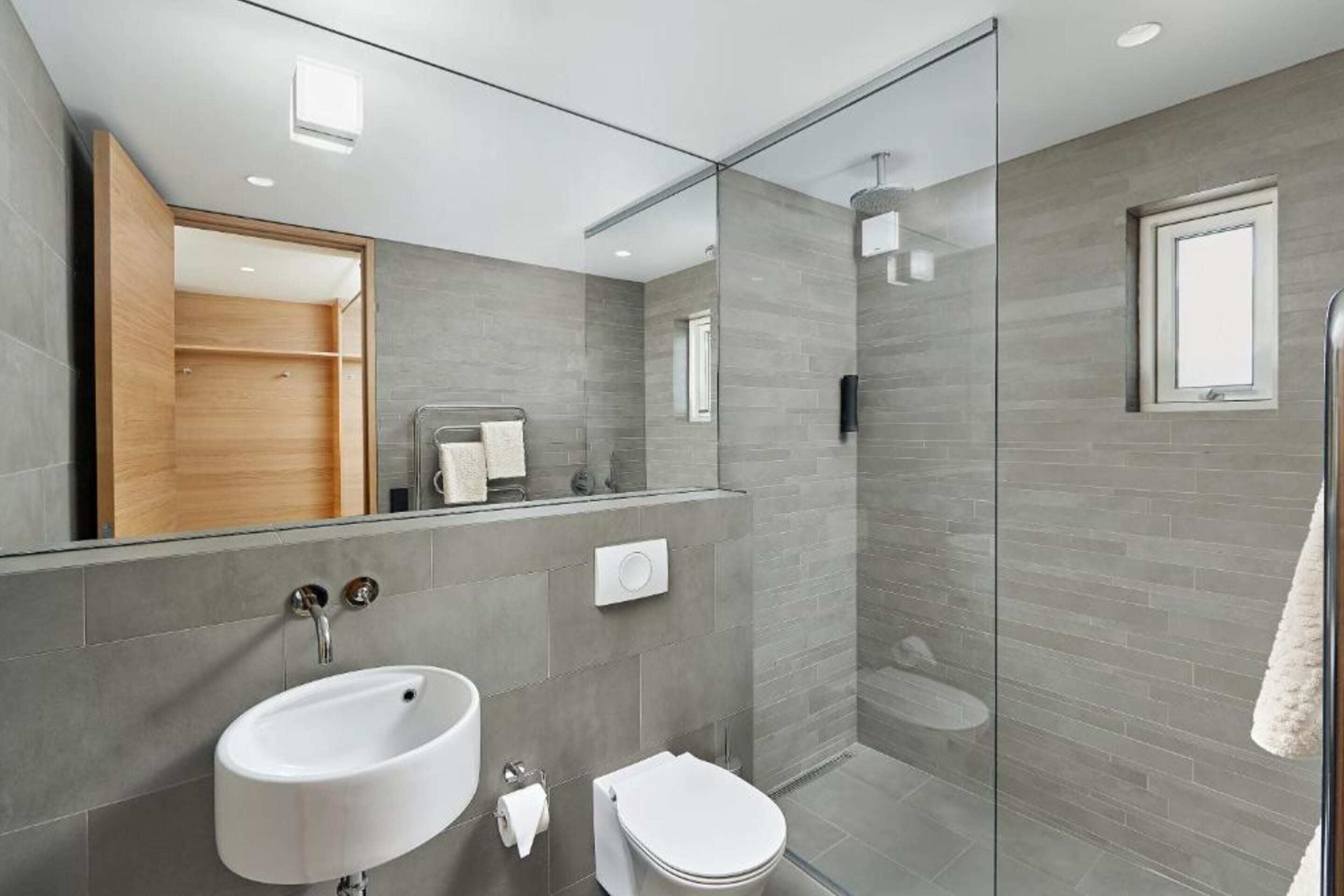 Une salle de bain moderne avec une douche à parois de verre, un lavabo et des toilettes.
