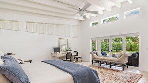 Une chambre spacieuse avec un grand lit, un bureau et une vue sur l’extérieur.