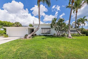 A modern two-story house with a garage, surrounded by a well-maintained lawn and palm trees. - Southern Breeze (West Palm Beach)