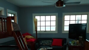 Una sala de estar con una cama nido, un sofá, una mesa de centro y una televisión.