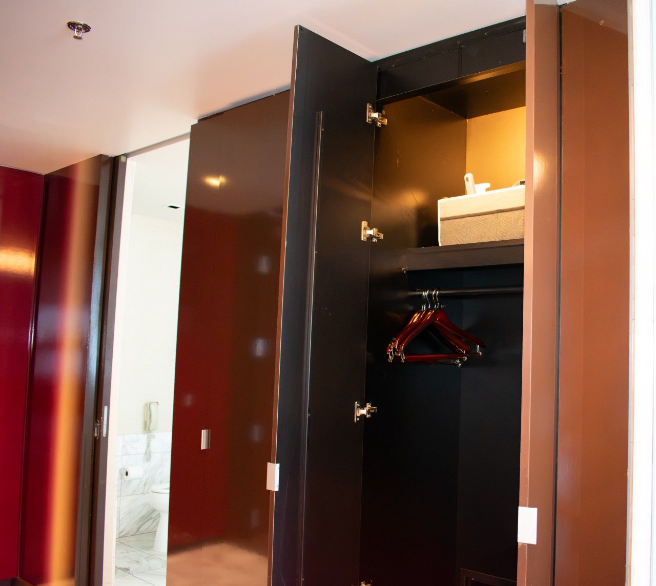 Ein begehbarer Kleiderschrank mit Kleiderstange und einer kleinen Ablagefläche.