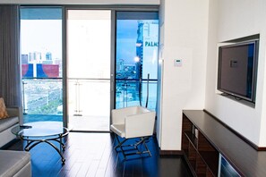 A modern hotel room with a balcony, a sofa, a coffee table, and a TV. - Palms Place Hotel StripView (Las Vegas)