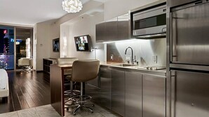 A modern kitchen with stainless steel appliances, a bar area, and a seating space.