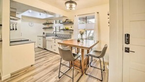 Une cuisine moderne avec une table à manger en bois, deux chaises et un îlot central intégré.