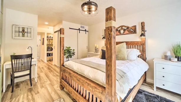 Une chambre à coucher avec un lit à baldaquin, un bureau, une chaise et une table de chevet.
