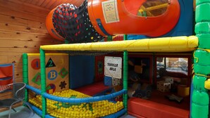 A play area with a ball pit, a slide, and a toddler area. - 13 Gower Holiday Village (Swansea)