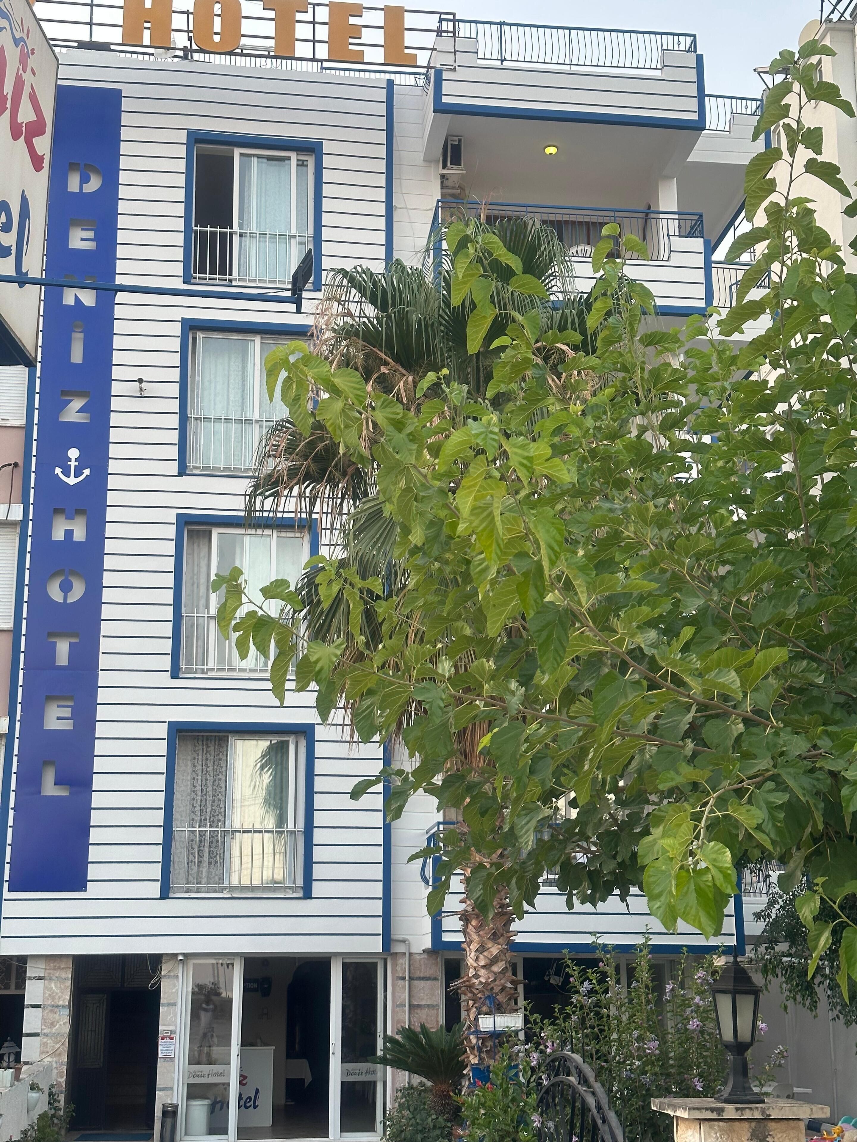 A hotel with a blue and white facade, multiple windows, and a visible entrance.