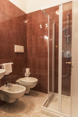 Une salle de bain équipée d’une douche, d’un bidet, de toilettes et d’un lavabo.