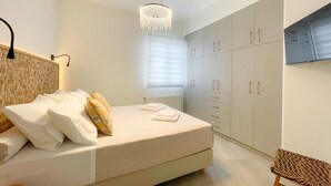 Una camera da letto moderna con un letto grande, un lampadario a sospensione e armadi a muro.