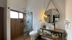 A modern bathroom with a toilet, sink, and shower area.