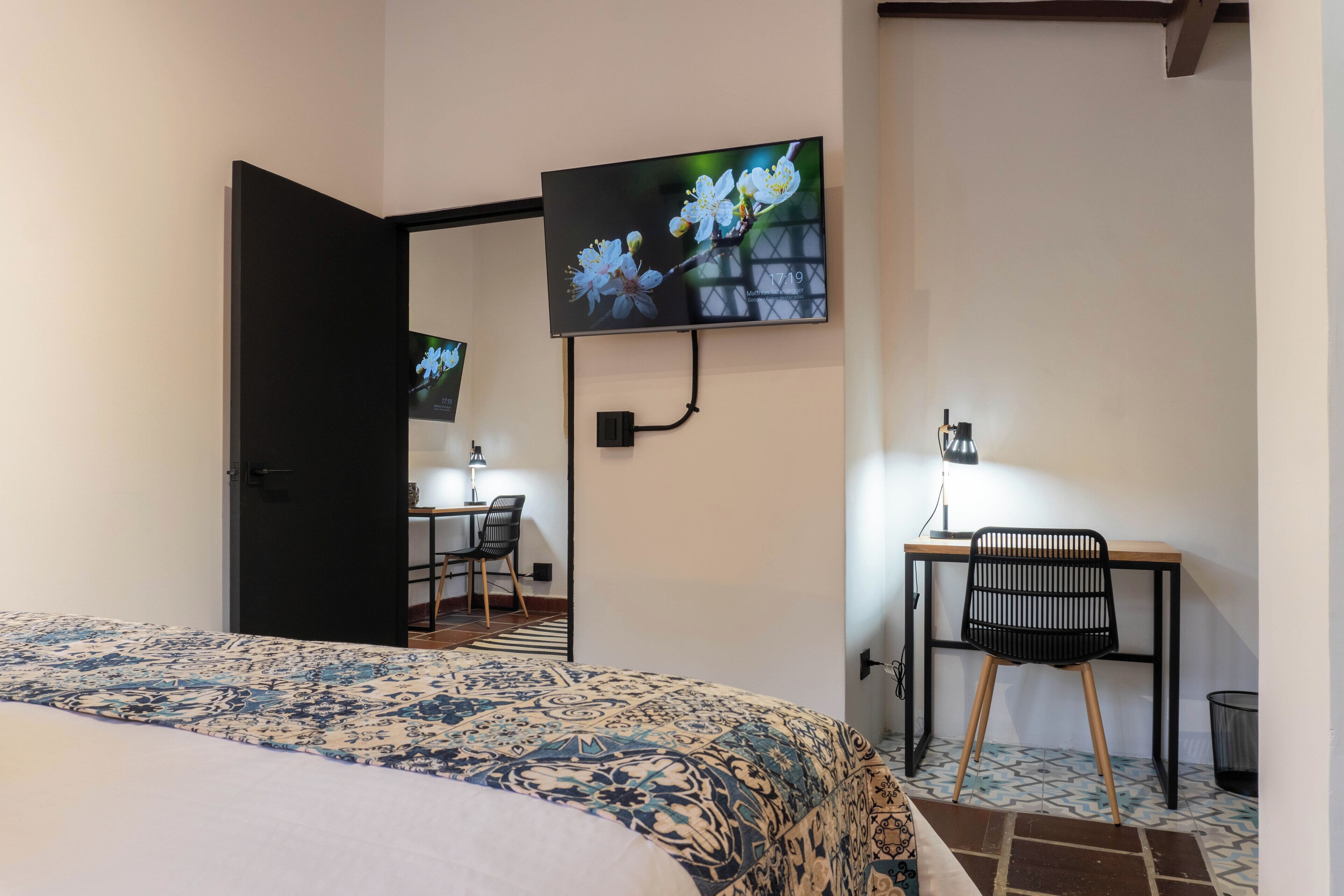 Un dormitorio con cama, escritorio y silla.