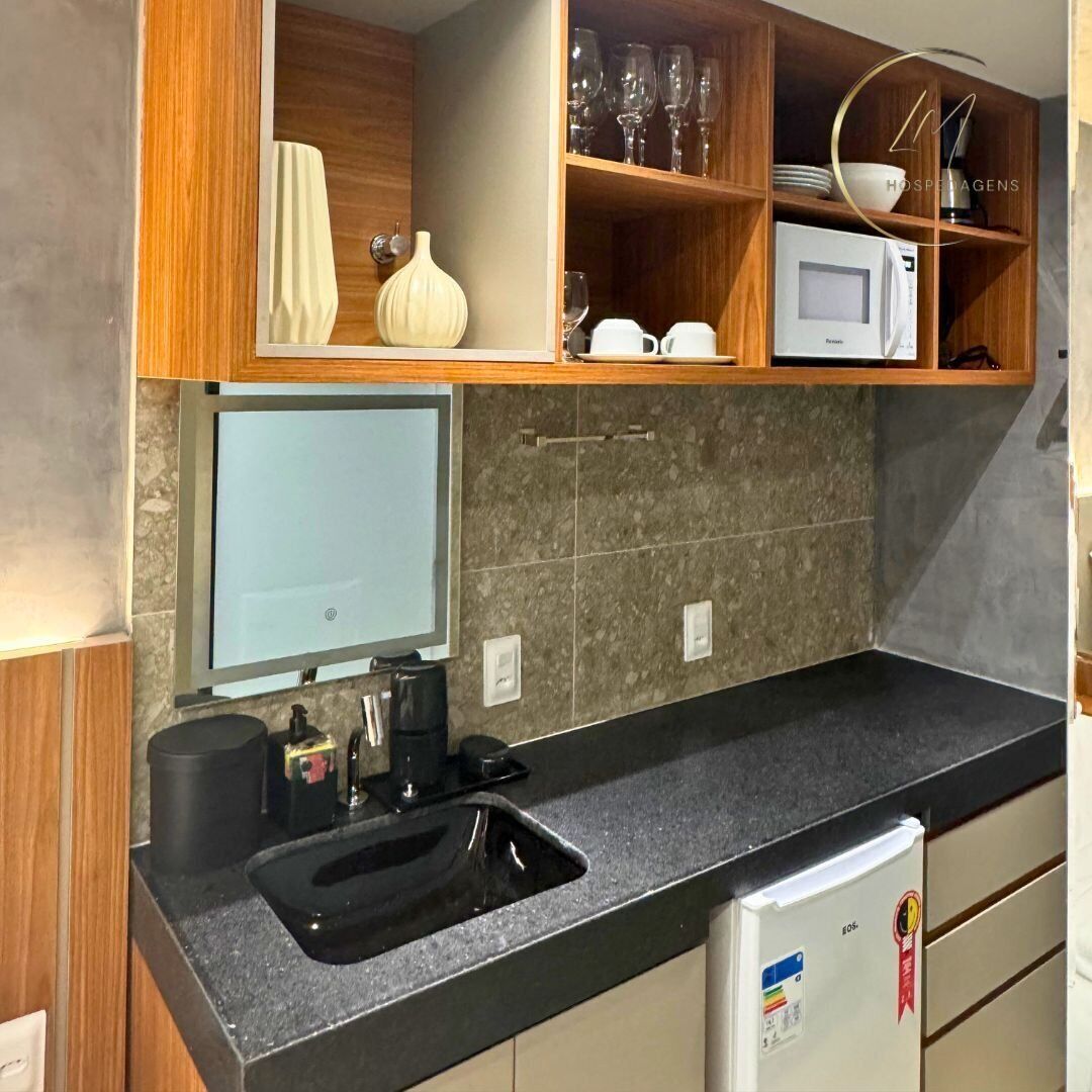Una cocina moderna con microondas integrado, un lavabo y armarios de madera.
