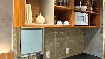 A modern kitchen with a built-in microwave, a sink, and wooden cabinets.