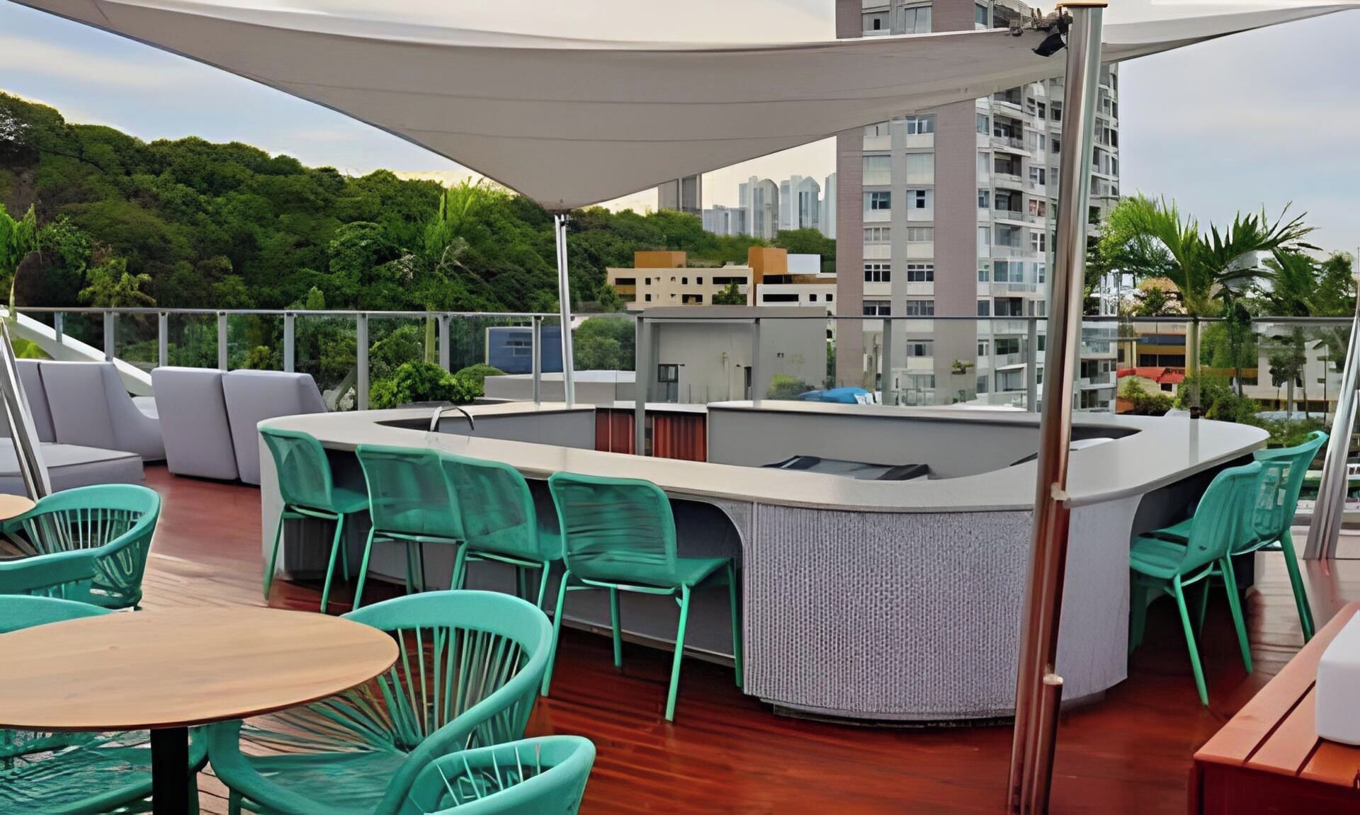 Un bar en la azotea con mesas al aire libre, una mesa de billar y vistas de la ciudad.