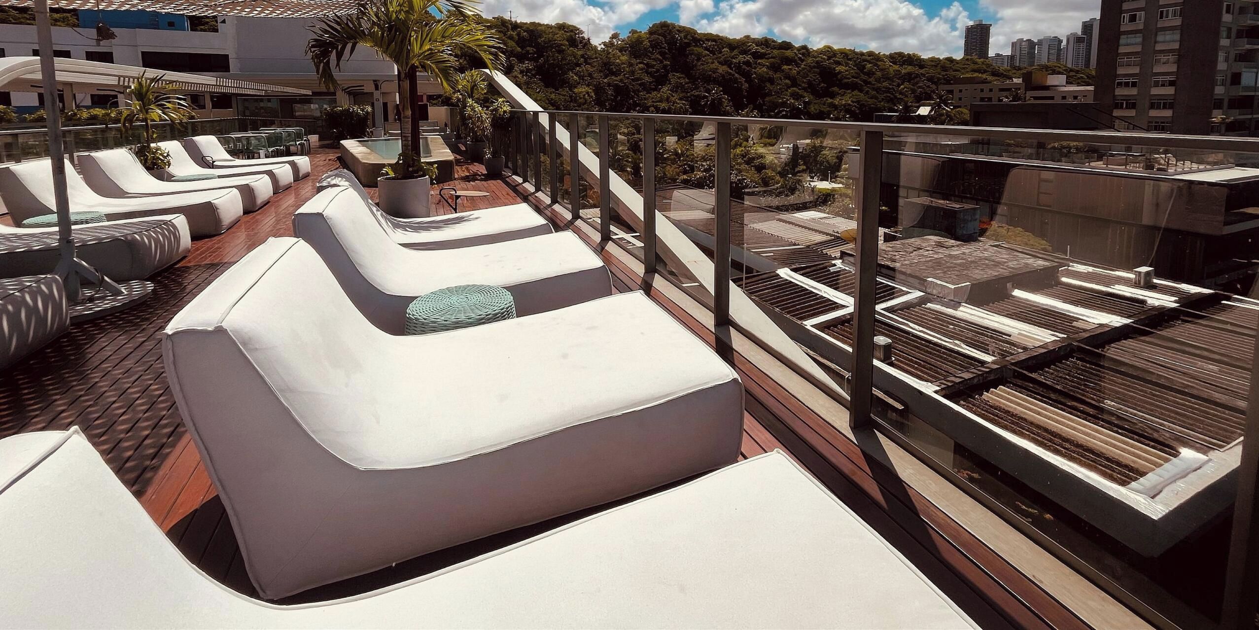 A rooftop terrace with lounge chairs and a pool.