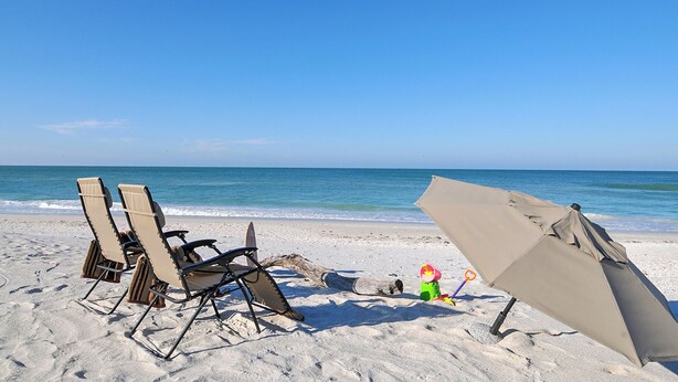 A beach with two beach chairs and a beach umbrella on the sand. - Charming 3-bedroom house with private pool  and in delightful Sarasota...  (Sarasota)
