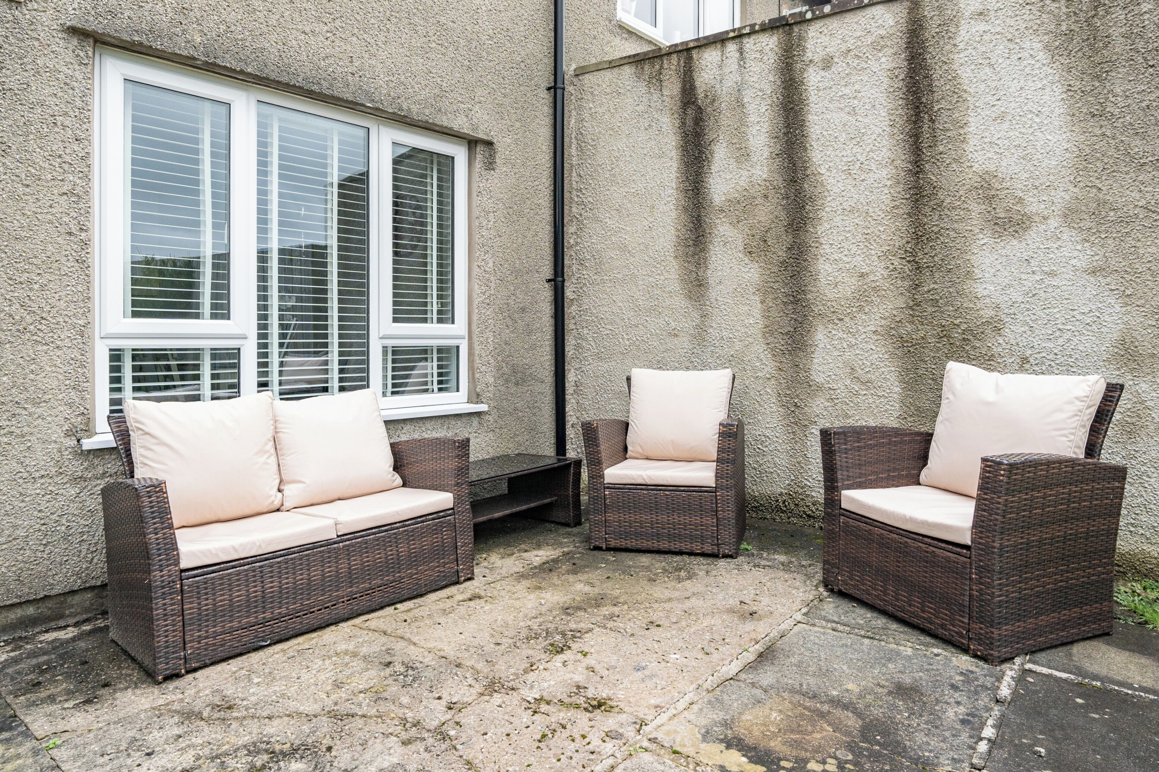 A patio area with wicker furniture and a window.