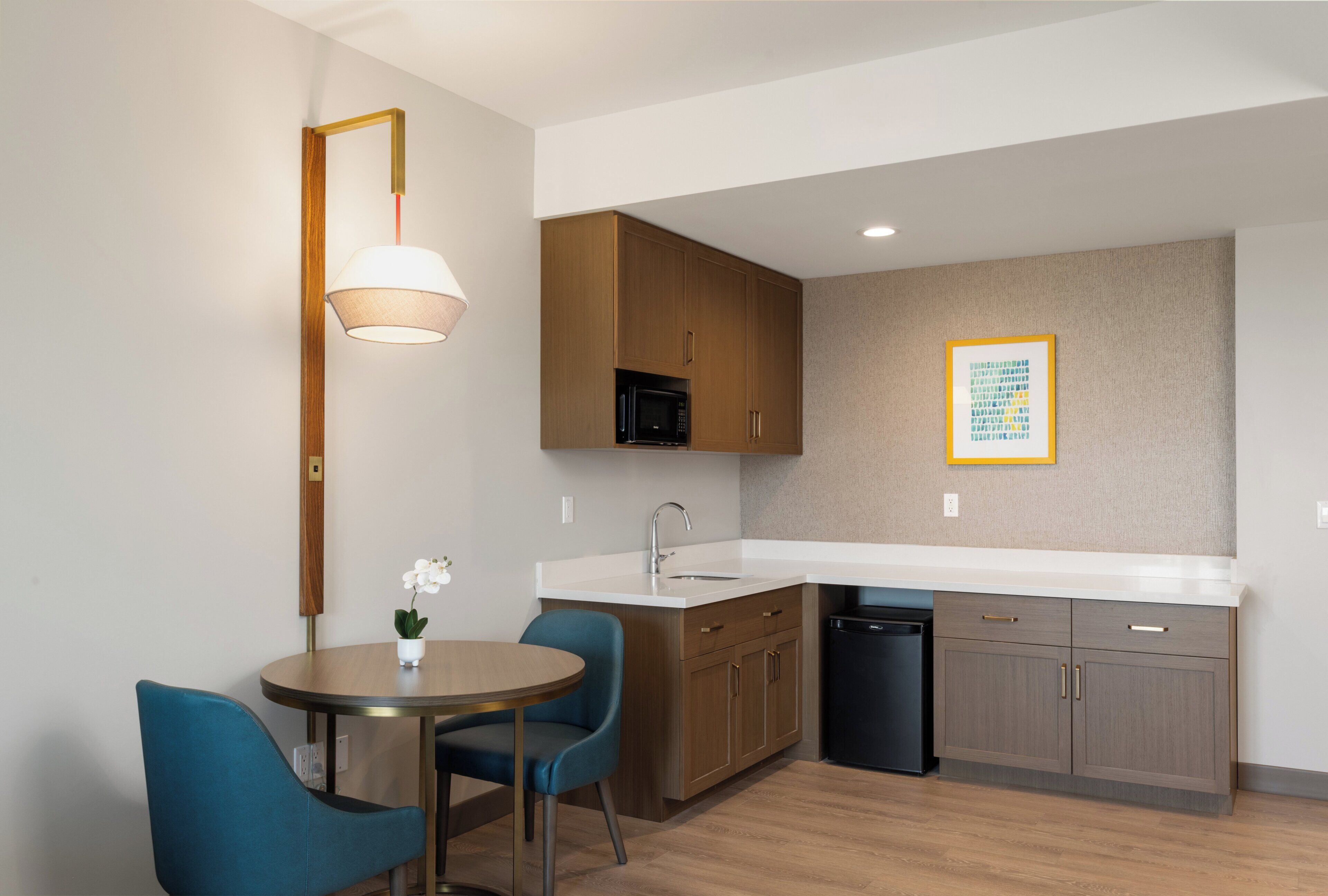 Cocina compacta con comedor, que incluye un lavabo, microondas y armarios.