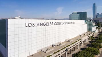 El Centro de Convenciones de Los Ángeles, con un diseño arquitectónico moderno, presenta una amplia fachada blanca y varios niveles con pasarelas accesibles.