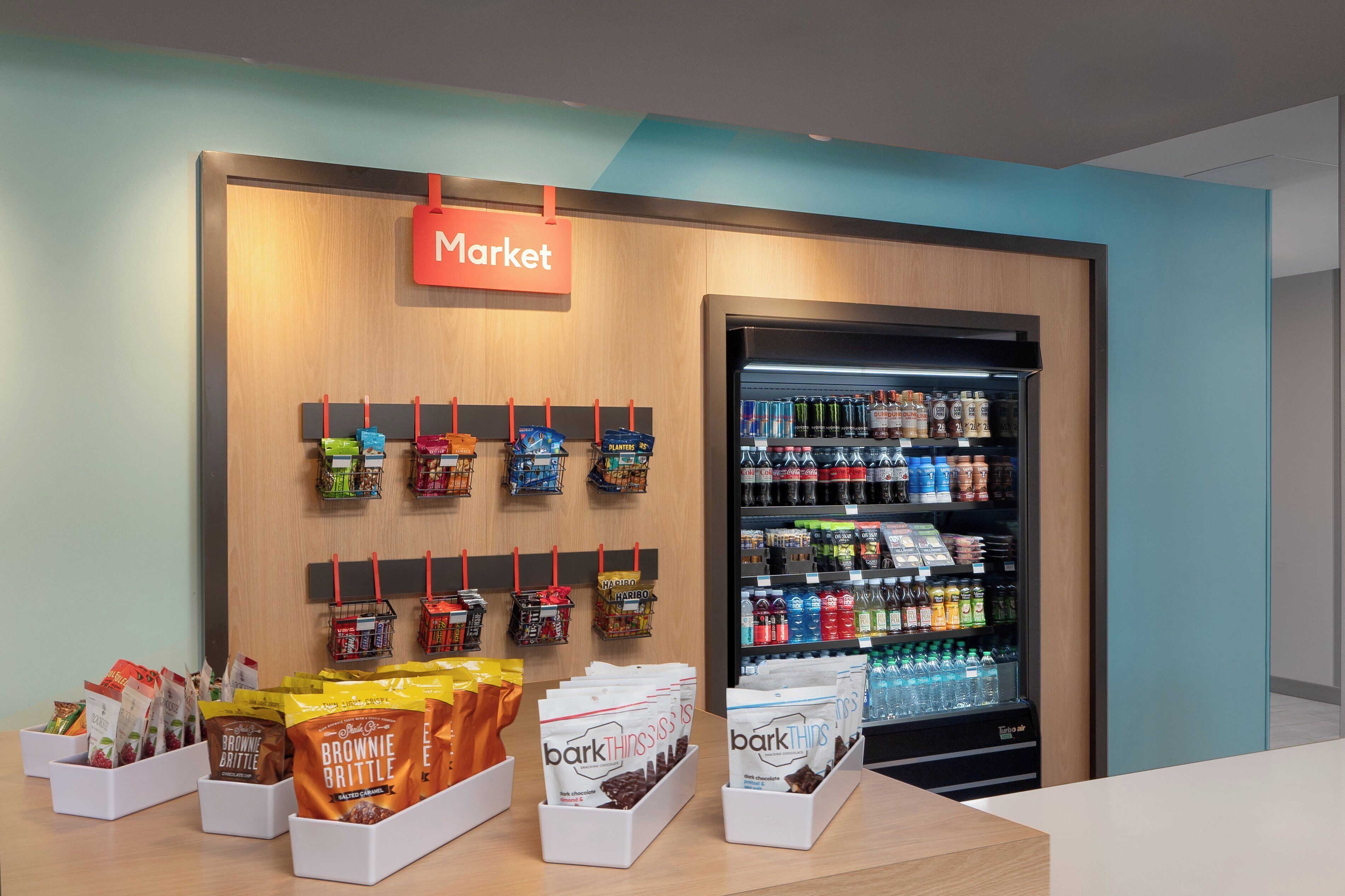A market area with a refrigerated display and various packaged goods.
