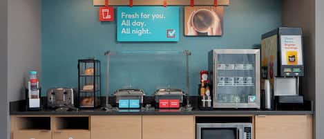 A breakfast bar with a coffee machine, toaster, and various food containers.