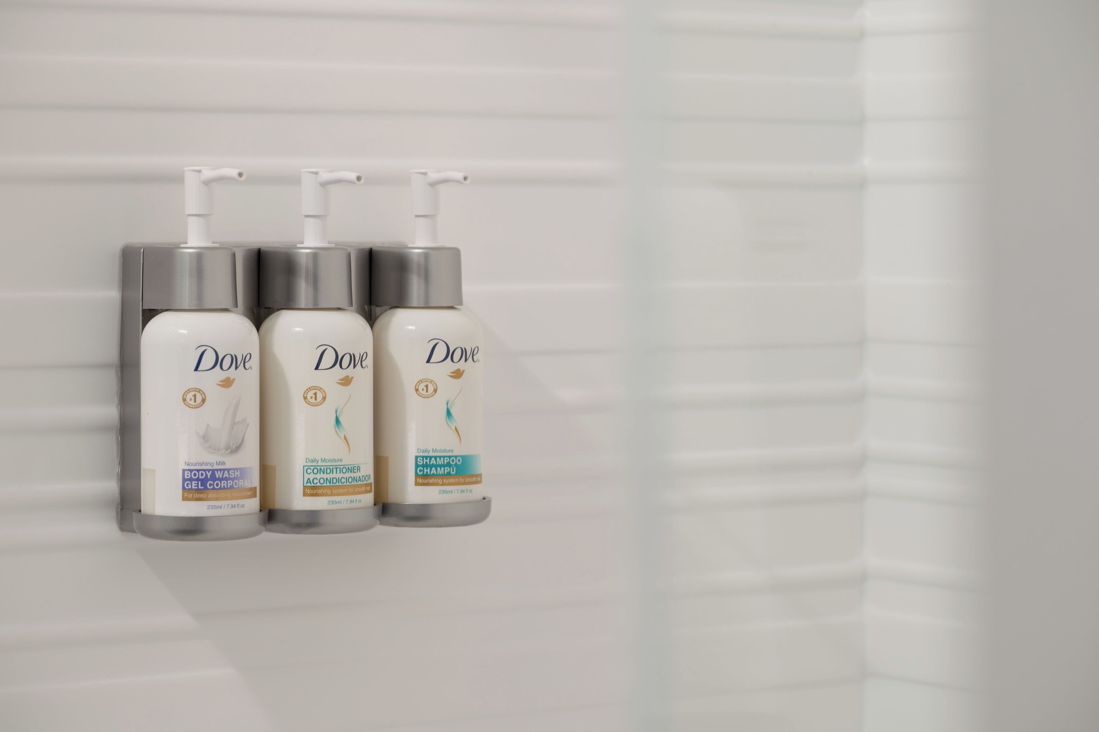 Tres productos de cuidado personal Dove en un baño.