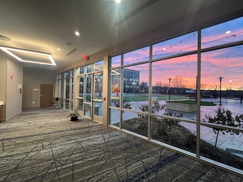 A building with a stone facade, outdoor seating, and string lights. at Holiday Inn Express & Suites Chicago Schaumburg by IHG
