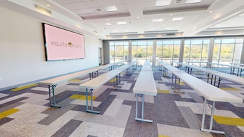 A hotel with a modern brick facade, electric vehicle charging stations, and a parking lot. at Holiday Inn Express & Suites Chicago Schaumburg by IHG