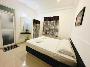 A clean, modern bedroom with a bed, a small bedside table, a mirror, and patterned curtains. - Jungle Fence (Induruwa)