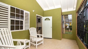 A room with two white chairs, a white door, and a window with metal bars. - Lot 40 Draxhall  (St. Ann's Bay)