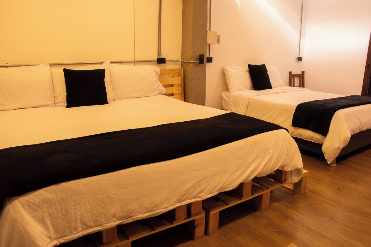 A room with two beds, wooden headboards, and a wooden floor.