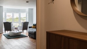 Een moderne woonkamer met een bank, fauteuils en een salontafel.