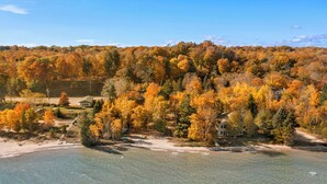A coastal property with clear waters, autumn foliage, and multiple buildings. - Lower Terrace in Three Pines Resort (Frankfort)