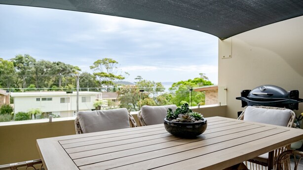 A balcony with a table, chairs, a grill, and a potted plant. - Anchors at Mollymook Beach (Mollymook)
