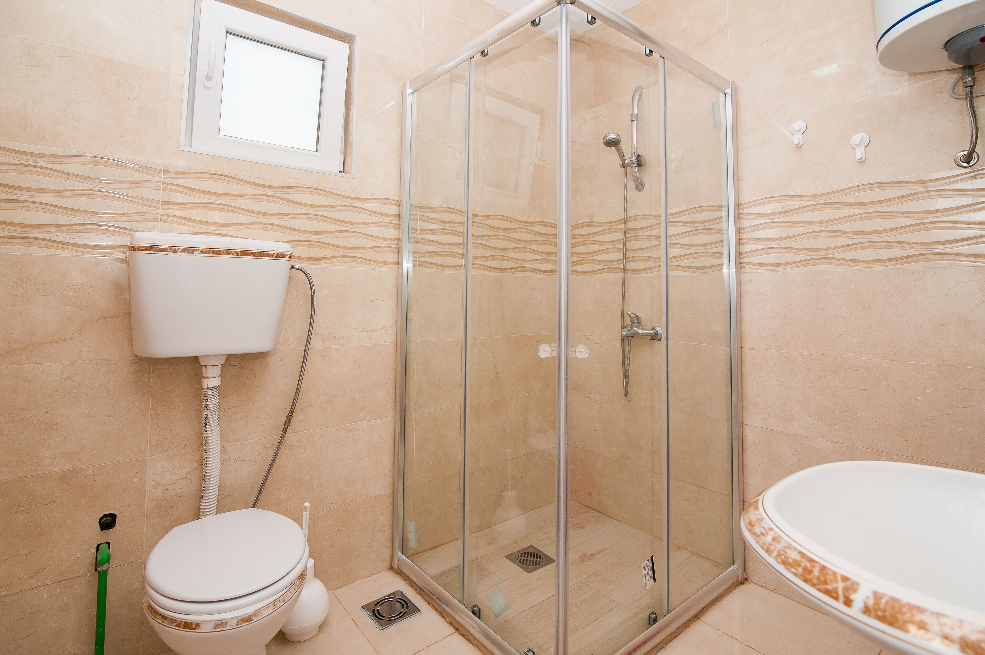 A bathroom with a glass-enclosed shower, a toilet, and a bathtub.