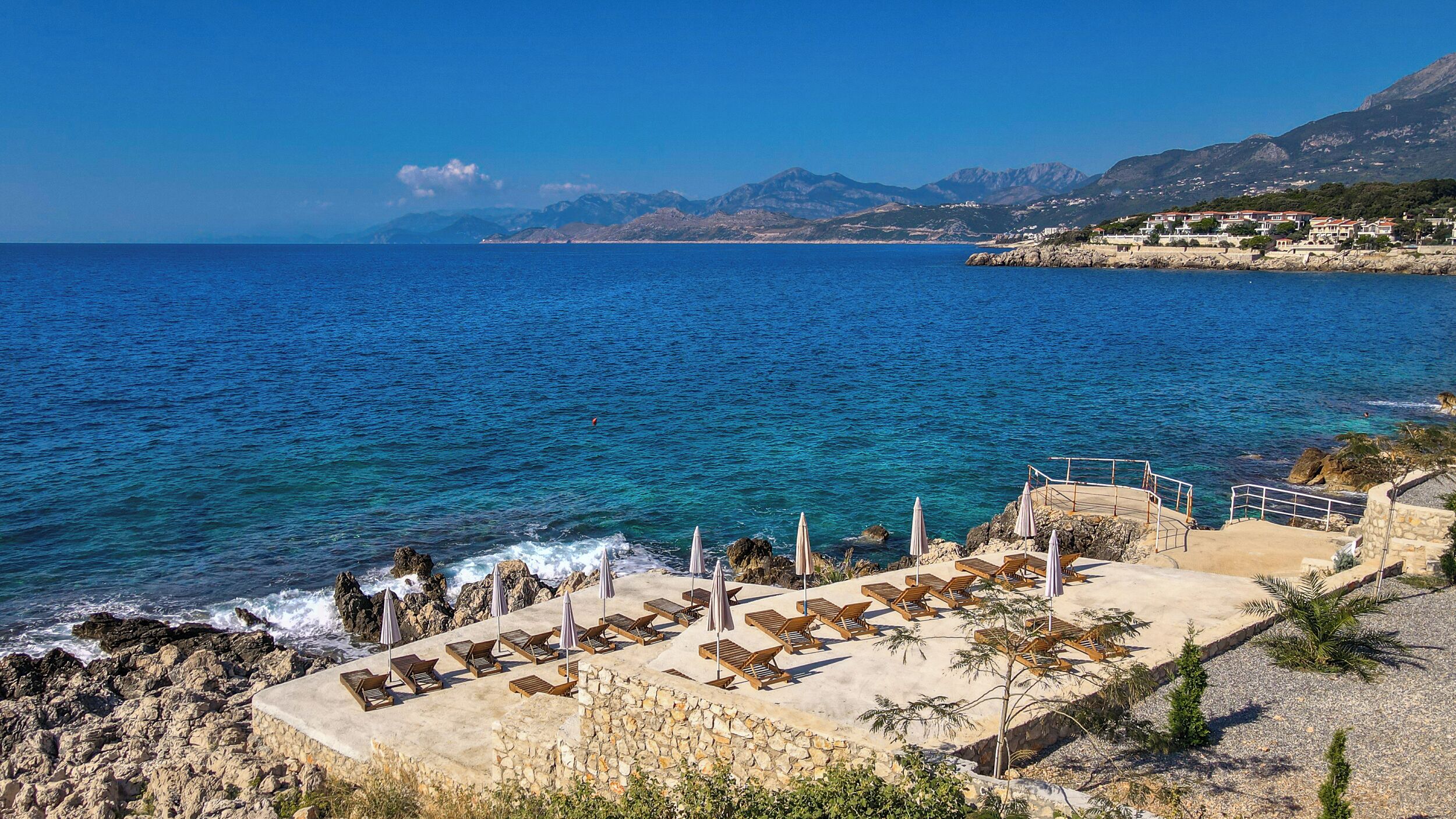 Playa privada, playa de arena negra, camastros y sombrillas 