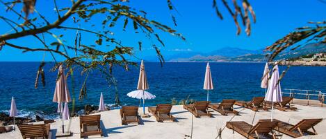 Private beach, black sand, sun loungers, beach umbrellas