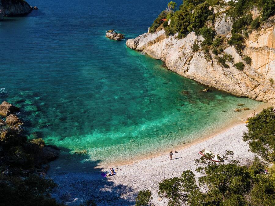 Privat strand, sort sand, solsenger og parasoller