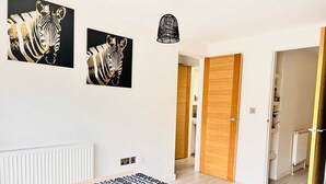 Een moderne woonkamer met een houten tafel, een kamerbreed tapijt en twee wanddecoraties met een zebra thema.