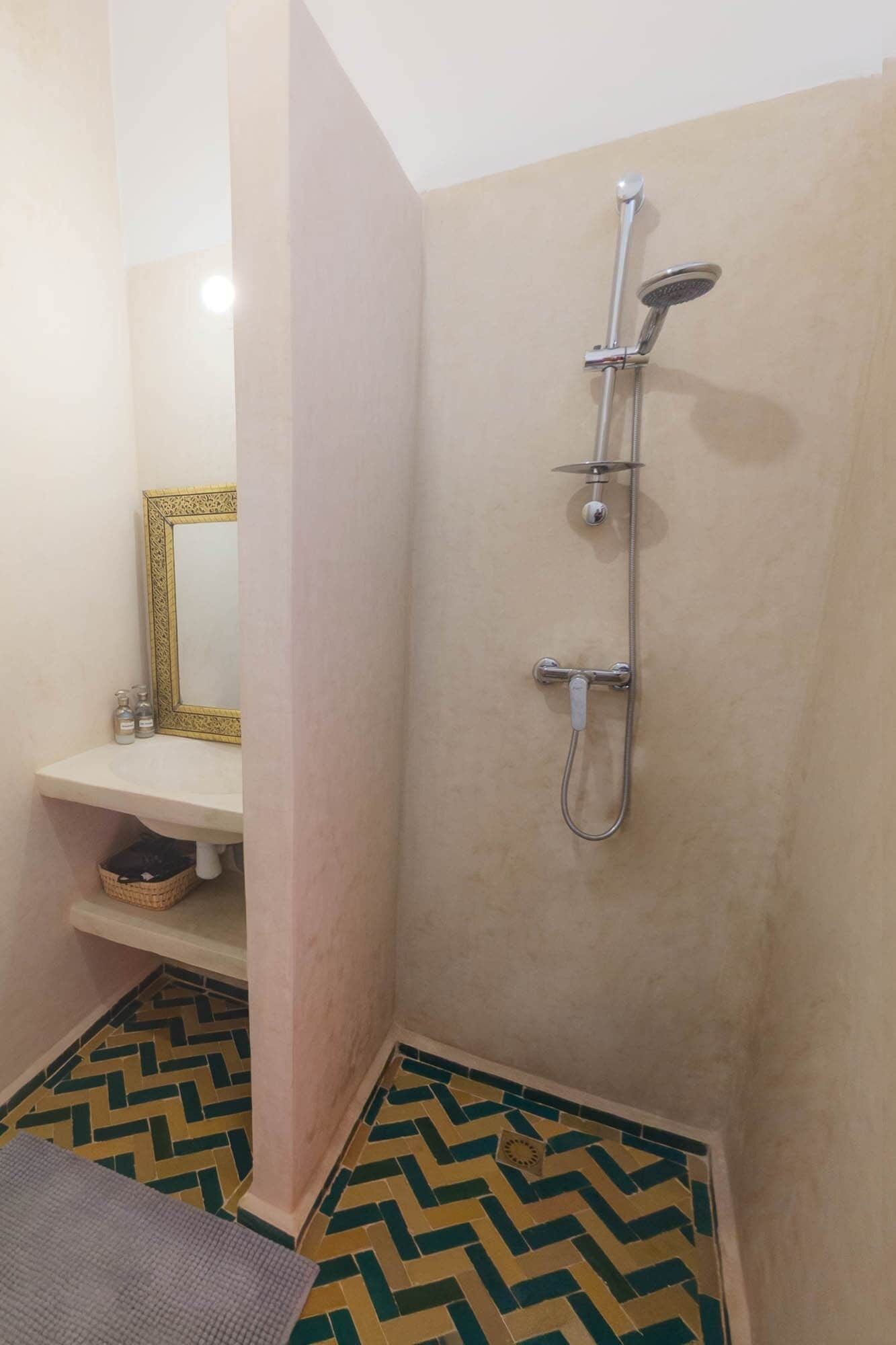 A bathroom with a shower, a sink, and a mirror.