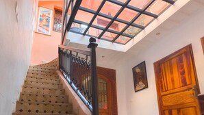 Una escalera con suelo estampado que lleva a un rellano con tragaluz.