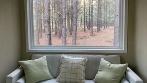 Una habitación con ventana que da a un bosque.