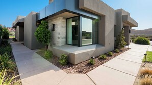 A modern house with a flat roof, large windows, and a concrete exterior. - Luxury 4-bedroom Retreat- stellar red rock views – St. George's Premier Getaway (Ivins)