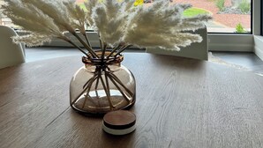 A table with a vase of pampas grass and a candle, overlooking a desert landscape with mountains. - Luxury 4-bedroom Retreat- stellar red rock views – St. George's Premier Getaway (Ivins)