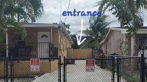 A gated entrance to a residential area with a clear path leading to a building marked with a 'DO NOT BLOCK DRIVEWAY' sign.