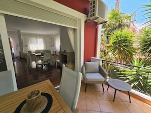A spacious living area with a fireplace, a dining set, and a balcony with outdoor furniture.