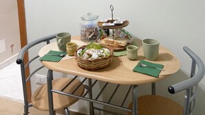 A dining area with a round table, metal chairs, and a buffet setup. - Angela's House (Monreale)